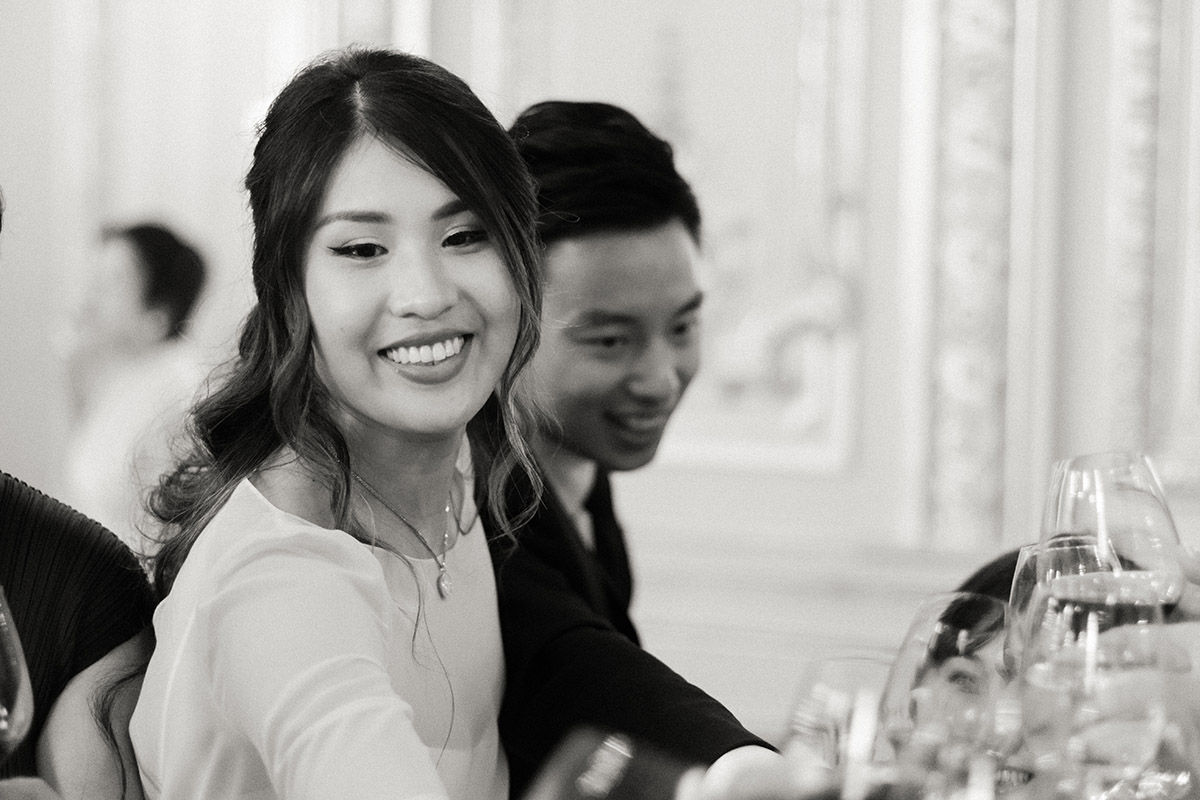 la mariée rigole avec ses invités un verre de vin à la main